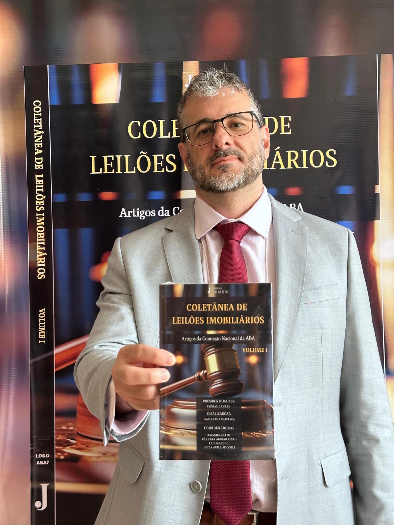 Aurélio Viana segurando o livro Coletânea de Leilões Imobiliários